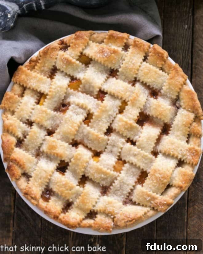 Overhead view of a Classic Peach Pie with a lattice crust, freshly baked and golden-brown.