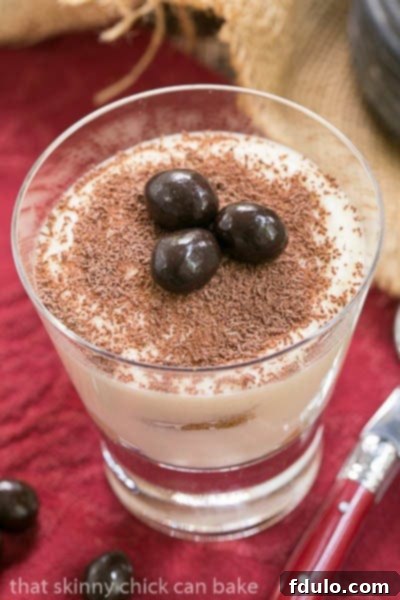 Classic Tiramisu in a cocktail glass garnished with chocolate-covered coffee beans.