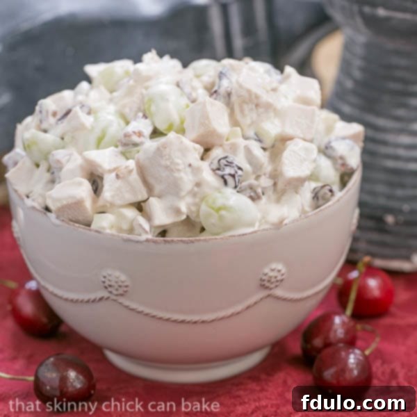 A pristine bowl of gourmet Chicken Salad, garnished with fresh herbs, resting on a striking red napkin.