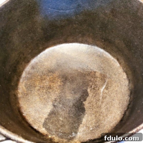 Smoky Dutch Oven Turkey Chili 3 Interior of a seasoned cast iron Dutch Oven, lightly coated with oil for cooking.