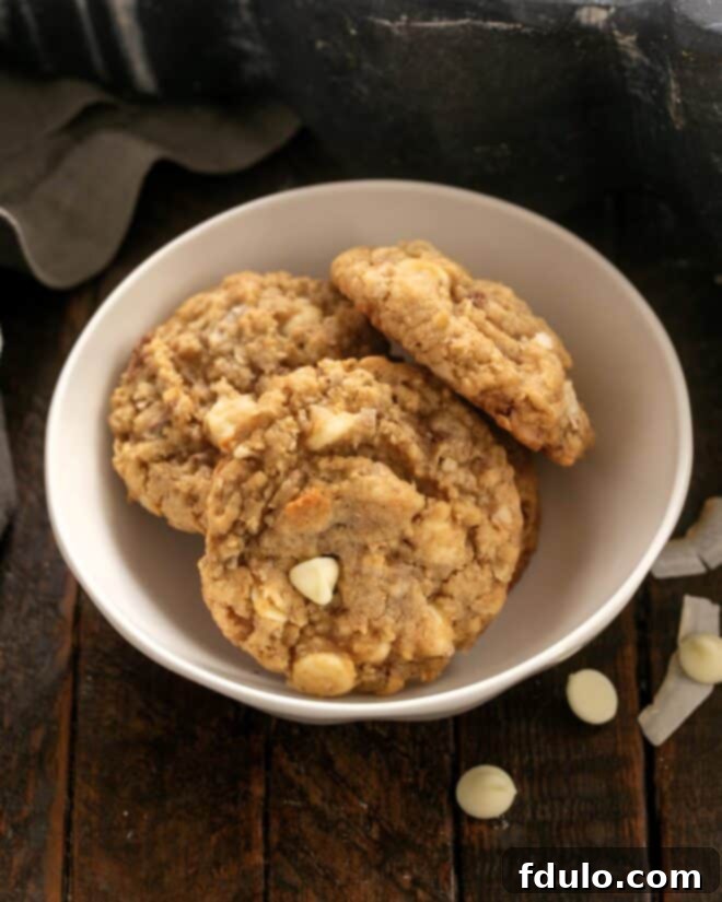 3 Oatmeal Toffee Cookies in a small white ceramic bowl.