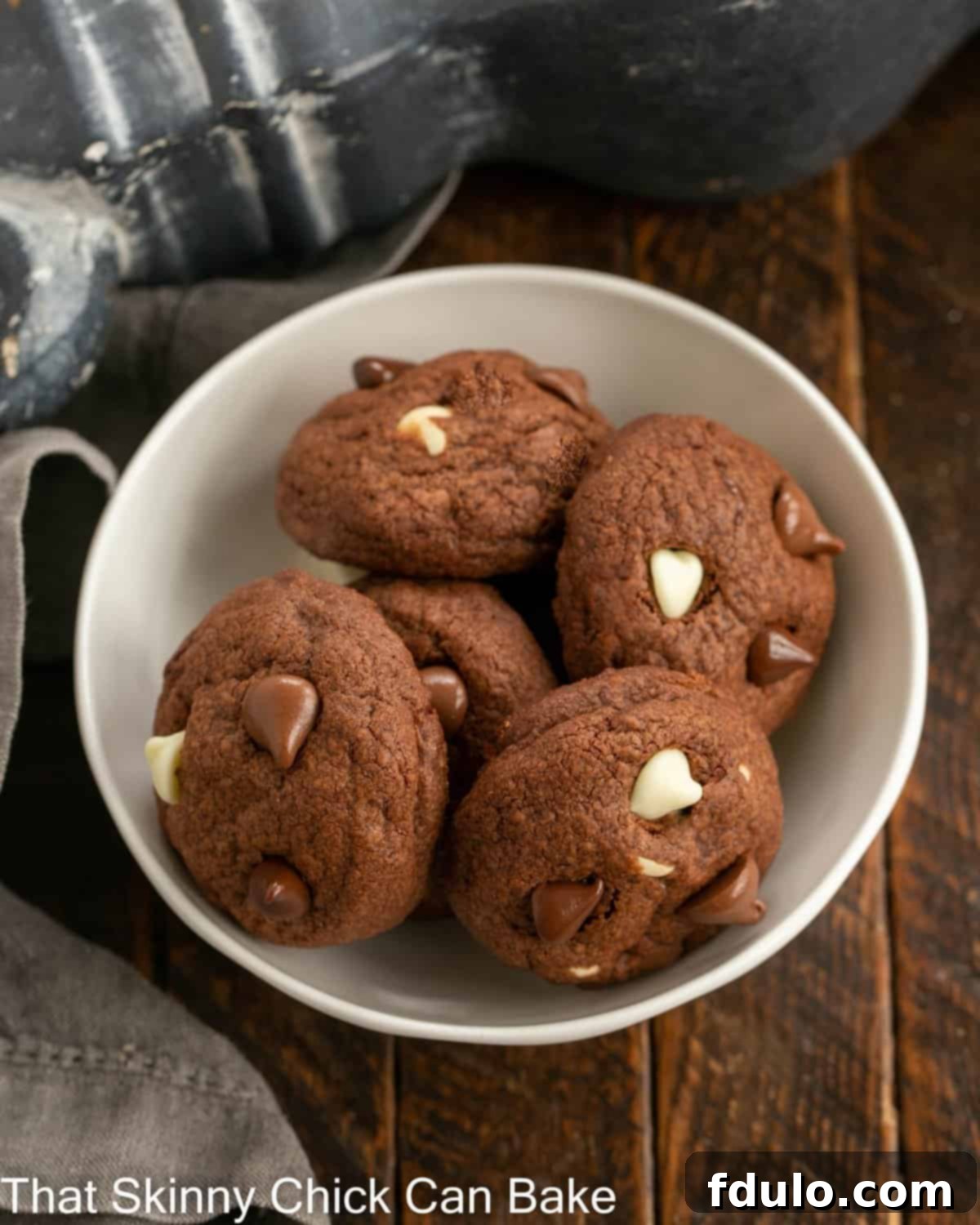 White bowl filled with 5 triple chocolate chip cookies.