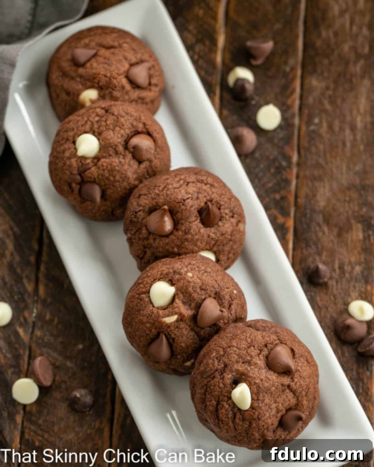 Overhead view of chocolate chocolate cookies on a narrow white ceramic tray.