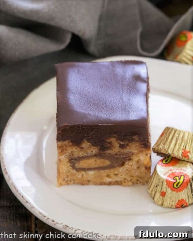 One  Peanut Butter Rice Krispie Treat on a round white plate with 2 mini Reeses 
