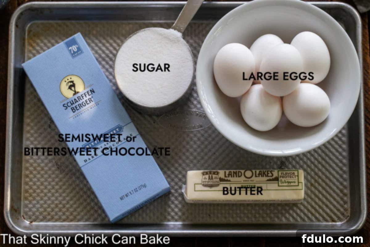 Velvet Chocolate Souffle Cake 2 A selection of high-quality ingredients, including chocolate, butter, and eggs, neatly arranged on a metal sheet pan, ready for baking.