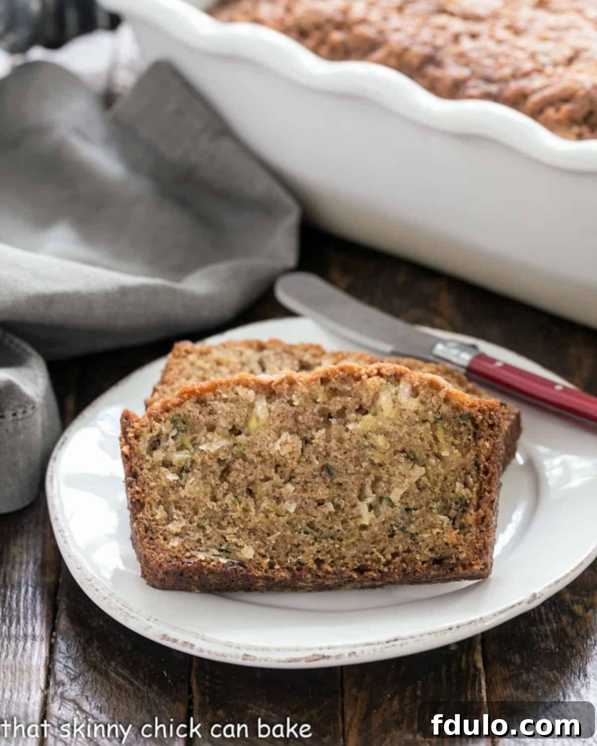 Slices of moist pineapple coconut zucchini bread on a white ceramic platter, ready to be served.