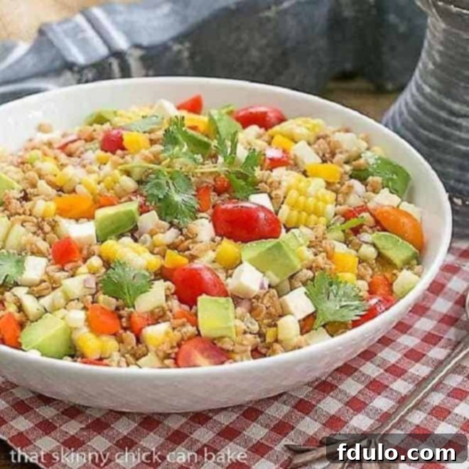Close-up of a refreshing Summer Farro Salad in a white serving bowl, highlighting the colorful vegetables and grains.