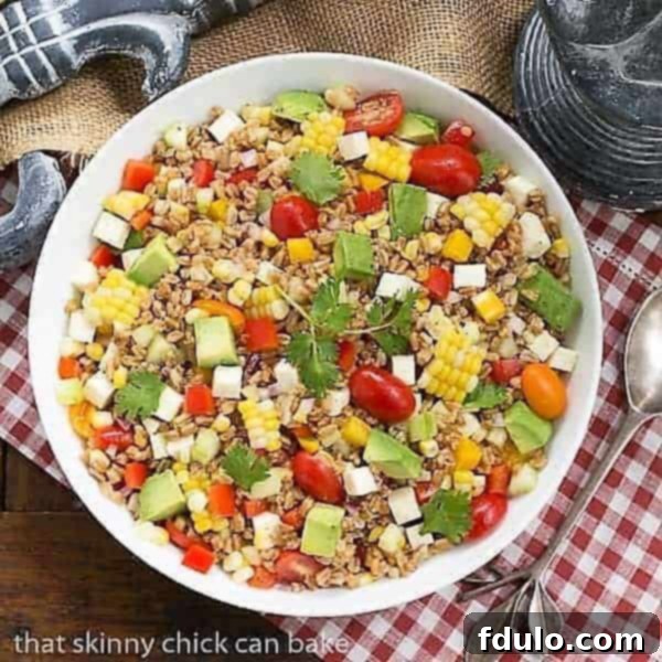 Overhead shot of a delicious Summer Farro Salad in a white serving bowl, ready to be enjoyed.