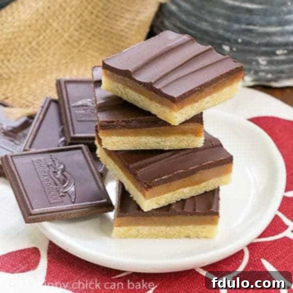 Ganache Topped Caramel Bars stacked on a round white plate, showcasing their distinct layers.