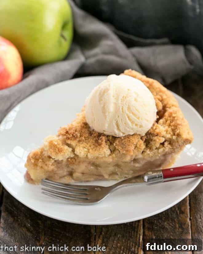 Dutch Apple Pie - Cinnamon spiced apples in a pastry shell with a streusel topping Slice of Dutch Apple Pie topped with a scoop of ice cream on a white dessert plate.