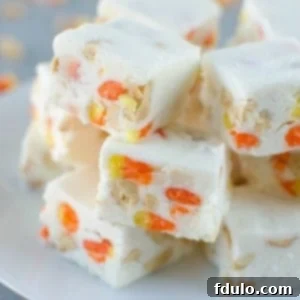Sweet and colorful Candy Corn Fudge, arranged in the iconic orange, yellow, and white layers.