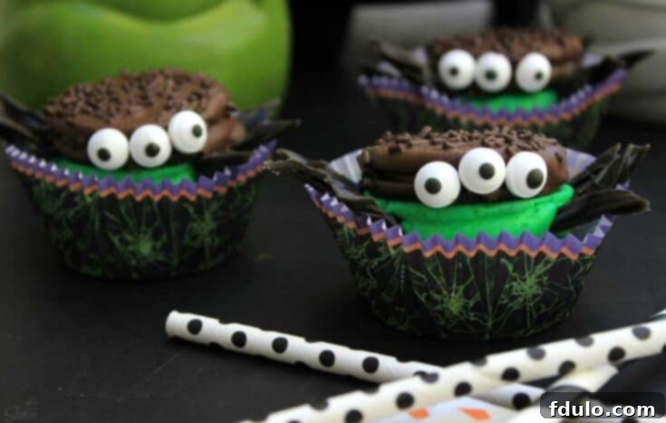 Oreo Spider Cookie Sandwiches, featuring doctored-up Oreos with green filling and candy eyeballs for a spooky effect.