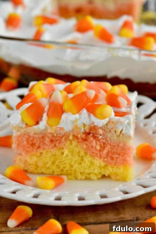 A vibrant Candy Corn Poke Cake, featuring the signature colors of the classic Halloween candy, a fun treat for all ages.
