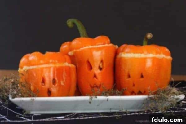 Shepherd's Pie creatively served inside carved orange bell peppers resembling Jack-o'-lanterns for a Halloween twist.