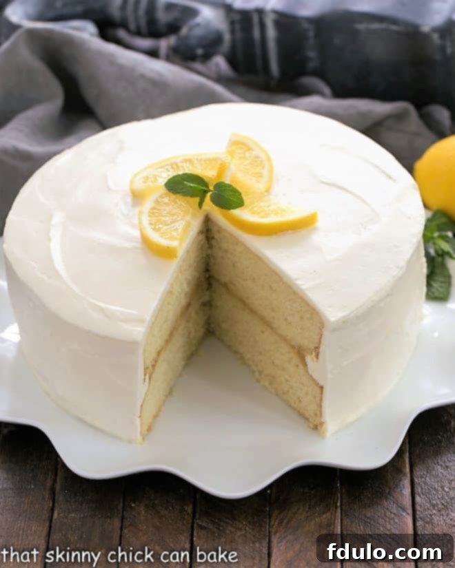 Lemon Cake with lemon curd filling on a white cake plate with a slice removed