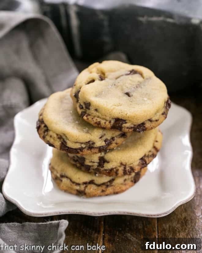 Layered Chocolate Chip Cookies stacked on a square white plate, showcasing their rich texture and visible chocolate layers.