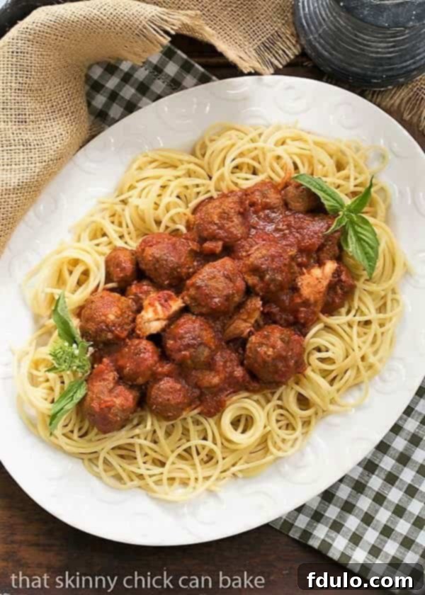 Classic Italian Meat Sauce generously spooned over a bed of al dente pasta on a large white platter, ready to be served family style.