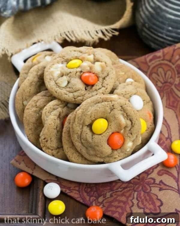M&M White Chocolate Macadamia Nut Cookies presented in a small ceramic terrine, emphasizing their homemade charm and colorful additions.