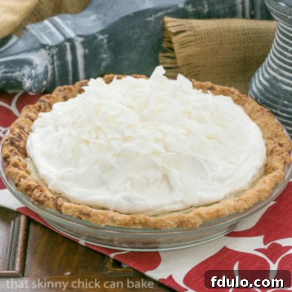 Stunning Whole Coconut Cream Pie - The Ultimate Festive Dessert The full Coconut Cream Pie, exquisitely garnished with toasted shredded coconut, ready to be served at a festive table.