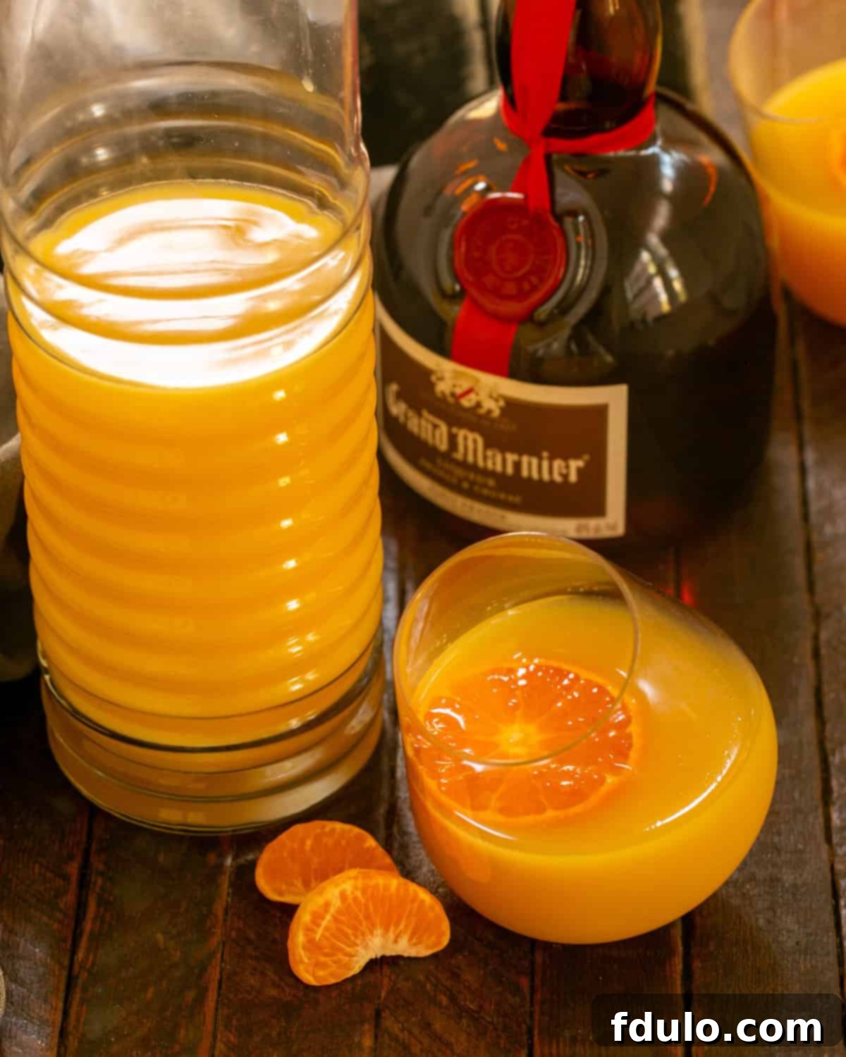 The Grand Mimosa 4 Grand Mimosa in a Viski glass next to a bottle of Grand Marnier.