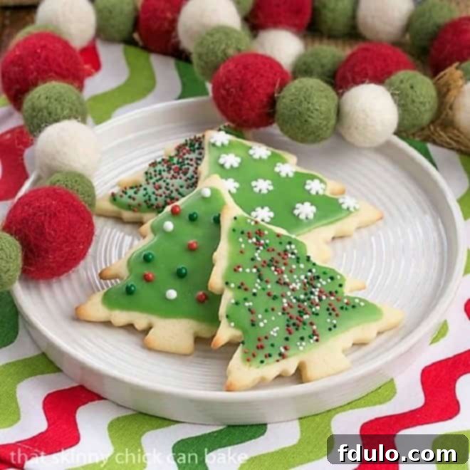 Best sugar cookies on a white plate with Christmas napkin and garland, perfectly baked and ready.