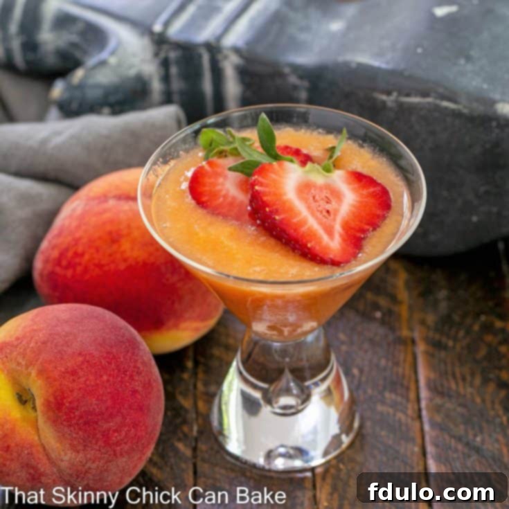Effervescent Peach Bliss 4 A peach bellini recipe topped with sliced strawberries next to 2 fresh peaches