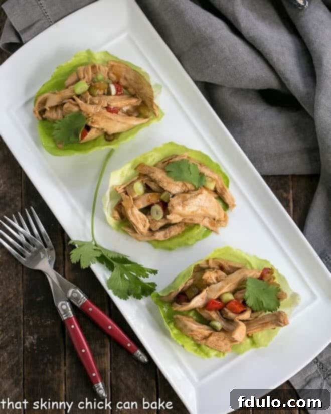 Overhead view of shredded chicken lettuce wraps on a white tray