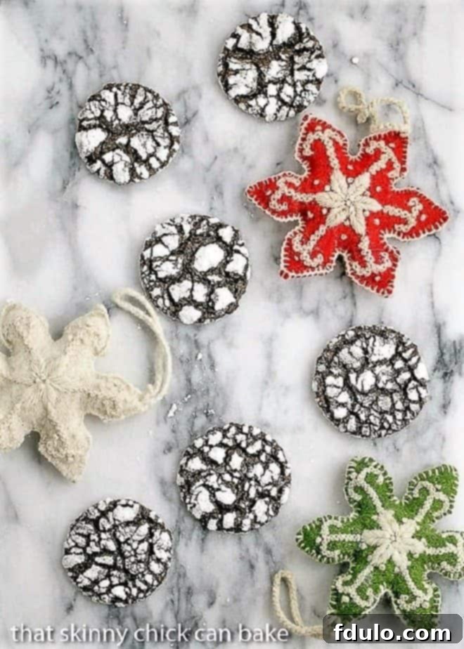 Beautifully crinkled Chocolate Crinkles Cookies on a marble tray with festive felt ornaments