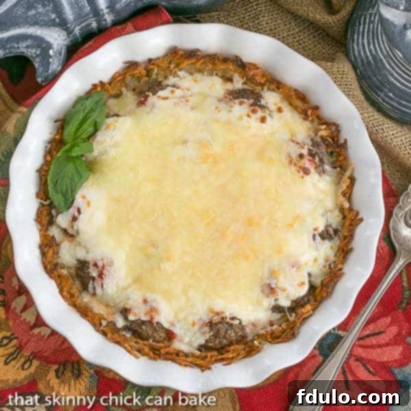 Roman Poutine Gratin 2 Close-up of a White ceramic pie plate filled with the golden-brown Italian Poutine Pie, showing the melted mozzarella and rich filling.