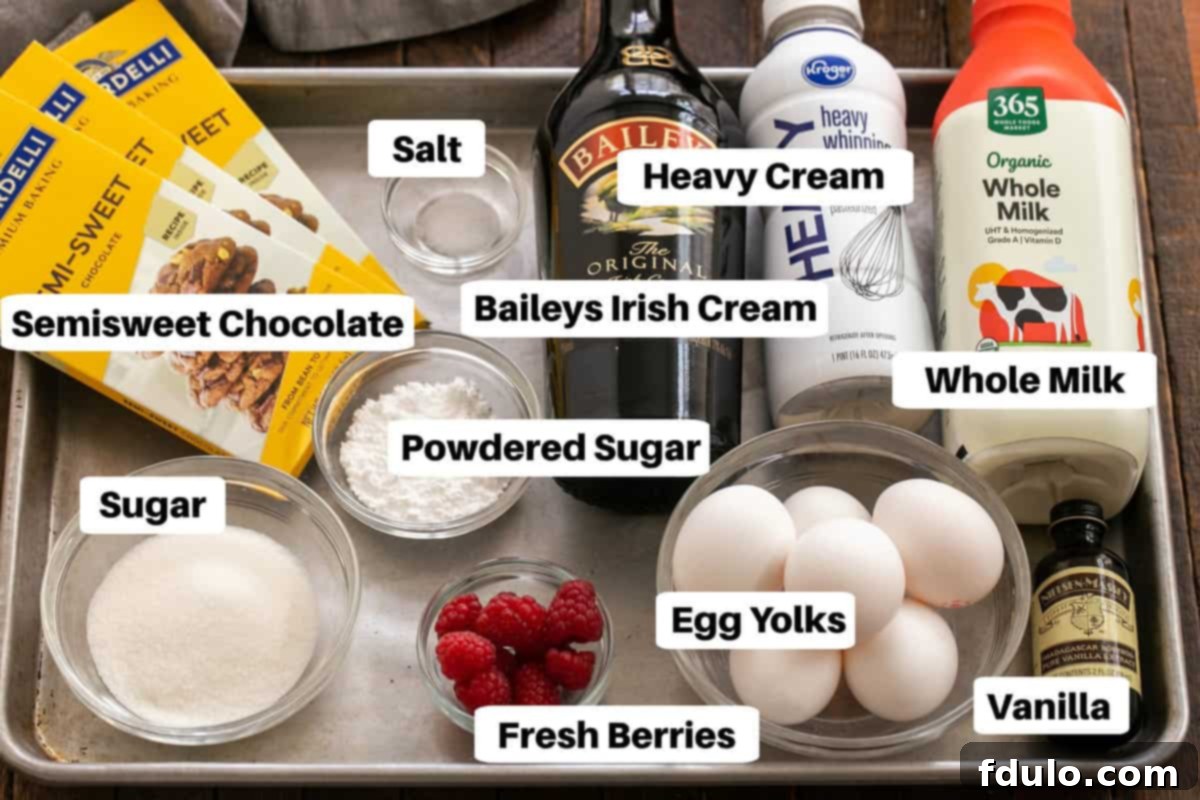 A meticulously arranged sheet pan showcasing all the essential ingredients for Irish Cream Pots de Creme, each item clearly labeled. Included are chocolate bars, a jug of milk, heavy cream, eggs, sugar, vanilla extract, and a bottle of Baileys Irish Cream.