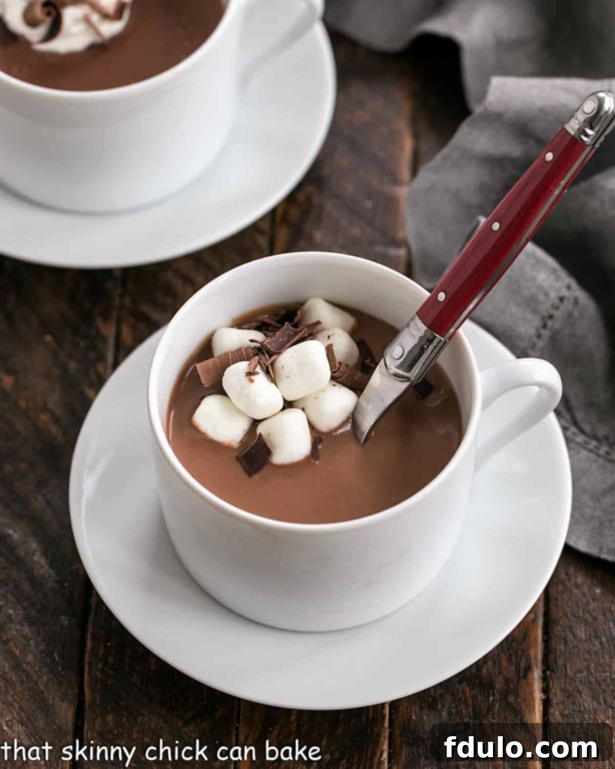 Luscious, thick Italian Hot Chocolate - This Cioccolata Calda is the BEST hot chocolate you'll ever make! Thick Italian hot chocolate in a white coffee cup with a red handle spoon inserted.