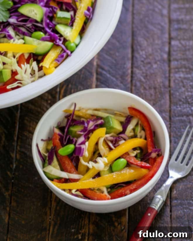 Overhead view of small bowl of Thai salad next to the serving bowl