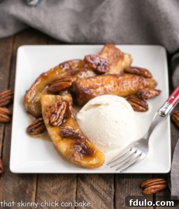 Bananas Foster on a square white plate with a scoop of vanilla ice cream, ready to be served.