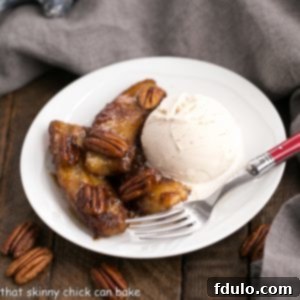 Bananas Foster served with ice cream and pecans in a white bowl.