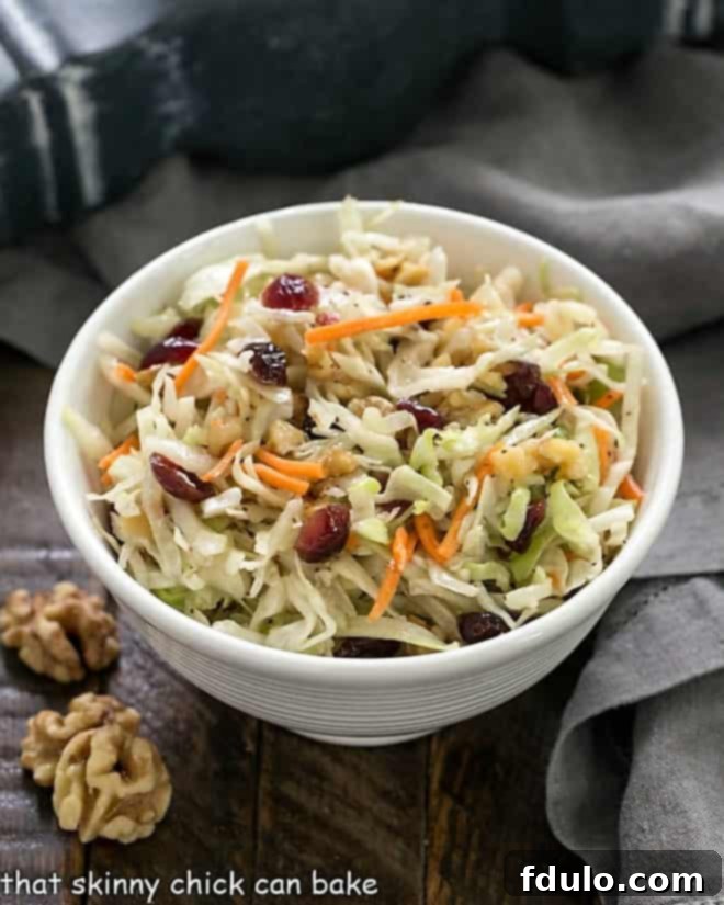 Zesty & Light Coleslaw (No Mayo) 3 Easy No-Mayo Coleslaw in a white bowl with walnuts to garnish, as featured in the recipe card.