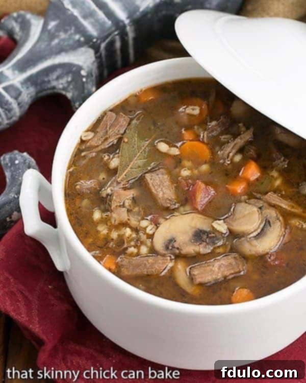 Homemade Beef Barley Soup - Worth the time and effort for this extraordinary soup! Homemade Beef Barley Soup in a white soup terrine, garnished with fresh herbs