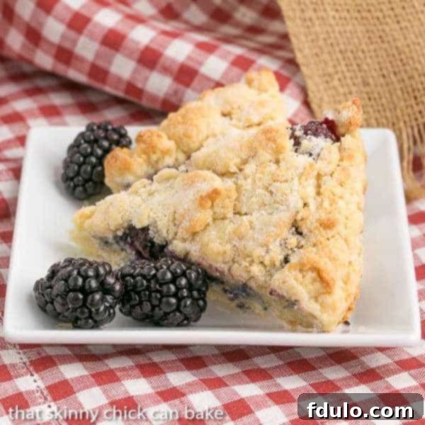 Fresh Blackberry Scones with Cream on a white square plate.