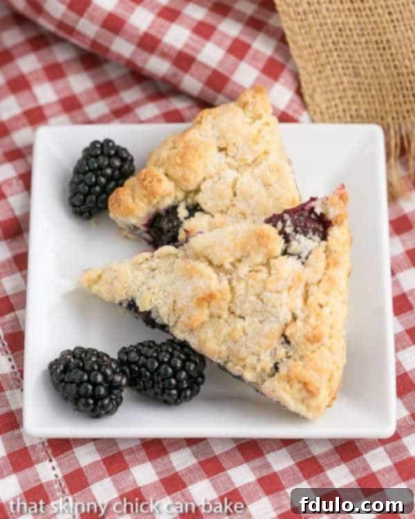 Overhead view of 2 of the best scones recipe with blackberries on a white plate.