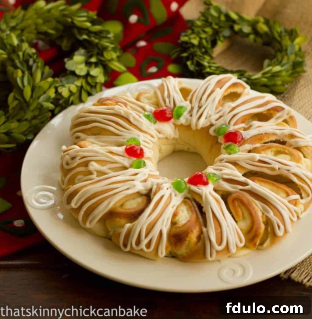 Holiday Cream Cheese Tea Roll on a white plate, garnished with candied cherries and icing