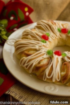 Baked tea roll on a white plate drizzled with icing and garnished with cherries