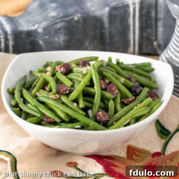 Side view of mustard green beans in a white serving bowl