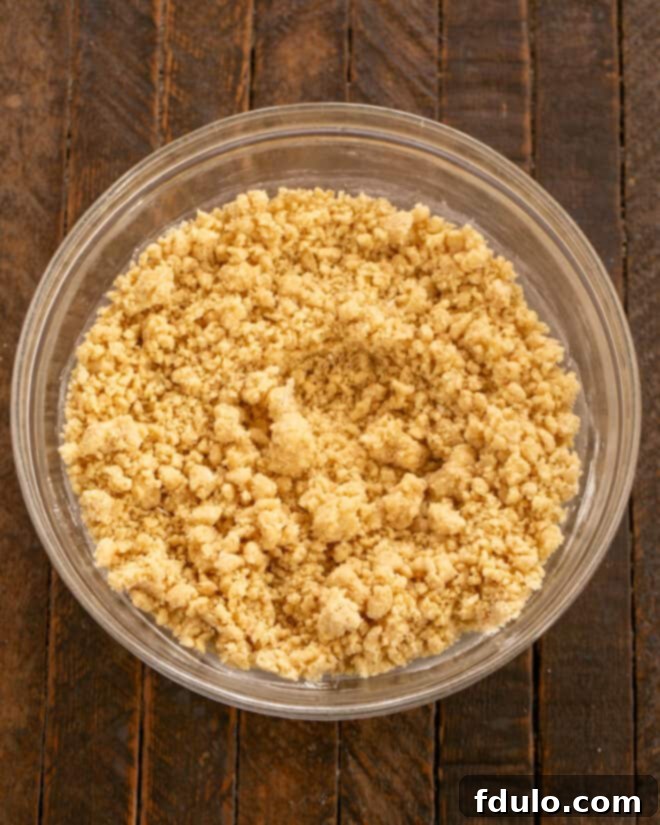 Step 3: Gradually stirring in the dry ingredients—flour, graham cracker crumbs, baking powder, and salt—into the wet mixture to form a cookie dough.