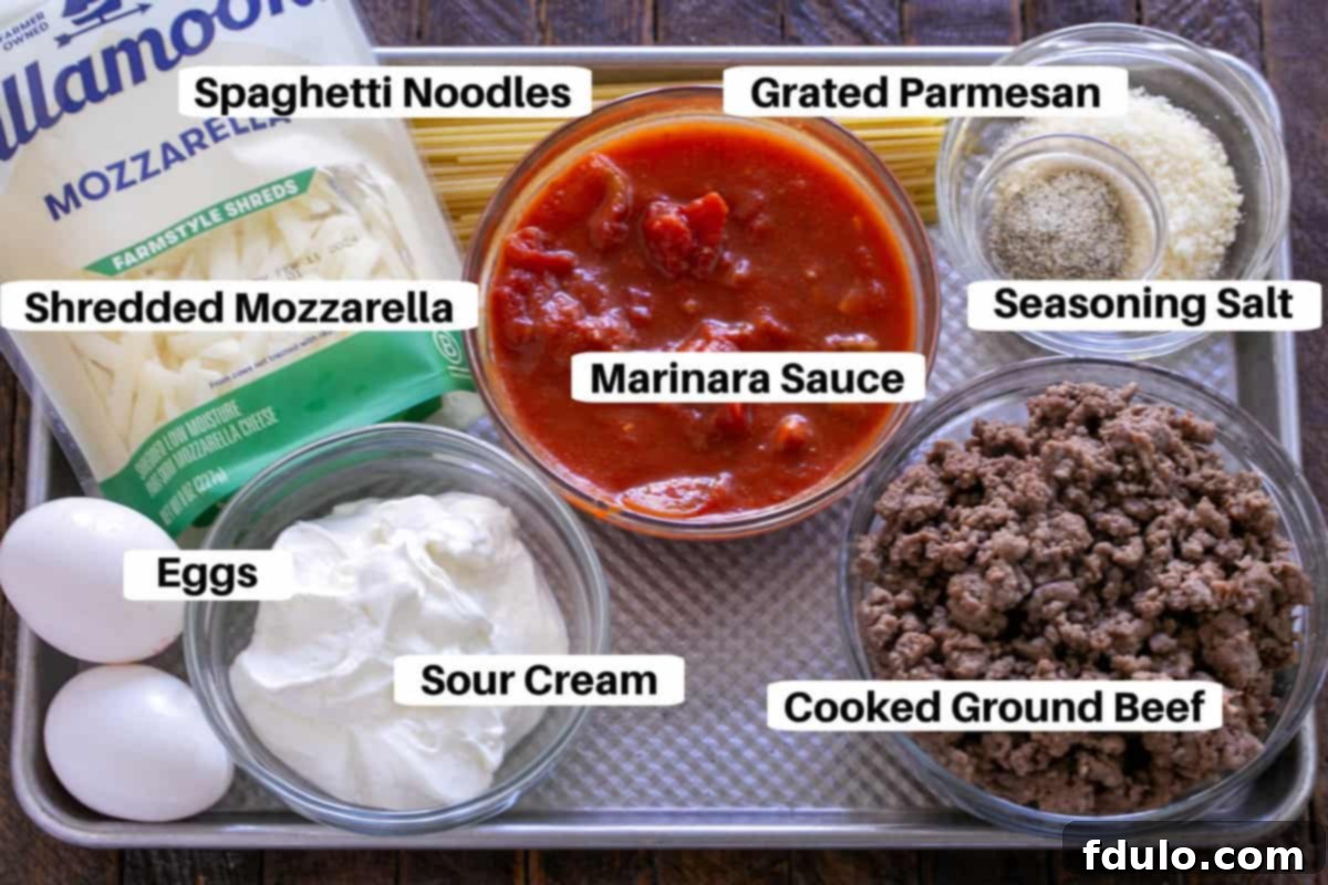 A meticulously arranged flat lay shot showcasing all the fresh, colorful ingredients needed for Spaghetti Pie, neatly labeled and thoughtfully positioned on a rustic wooden sheet pan, ready for efficient preparation.