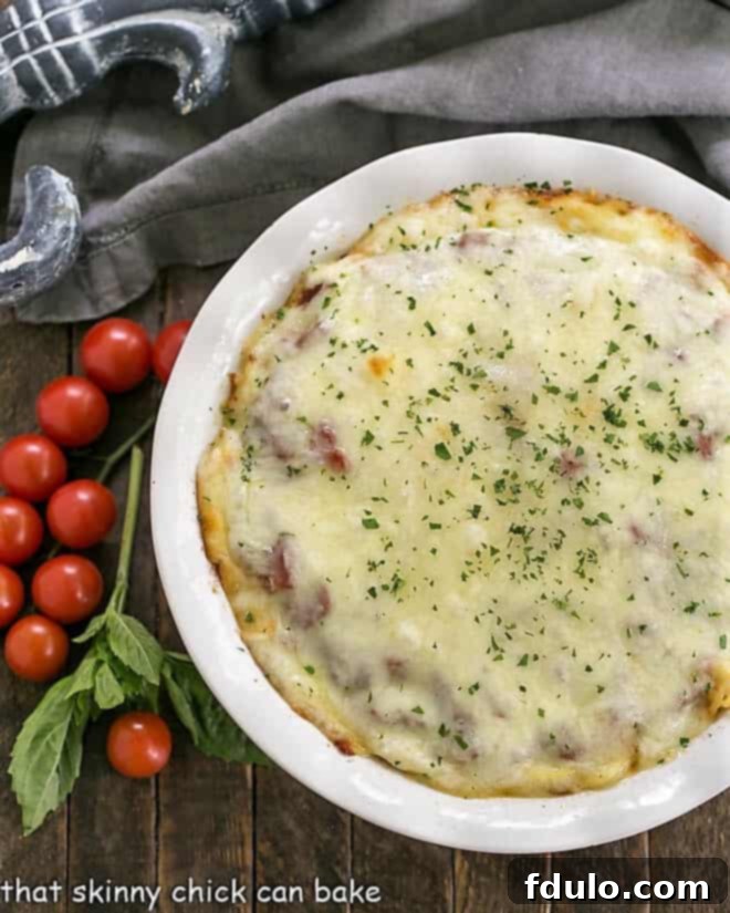 An inviting overhead view of the complete Spaghetti Casserole, showcasing its beautifully golden-brown, bubbly cheese topping, and visible layers of rich sauce and tender pasta, freshly baked and ready to be served.