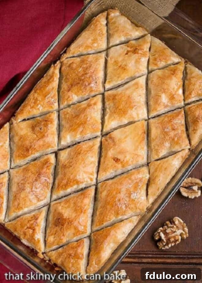 Overhead view of Classic Greek Baklava cut into diamond shapes in a glass 9x13-inch pan, glistening with syrup.