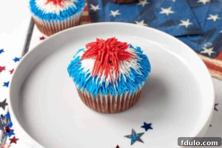 Red Velvet Patriotic Firework Cupcakes decorated with sprinkles and frosting, perfect for holidays.