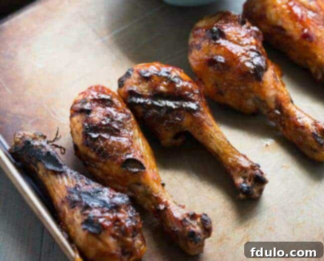 Grilled Chicken Drumsticks with a vibrant spicy BBQ sauce, perfectly charred and juicy.