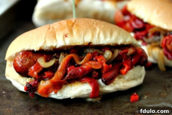 Grilled Sausage with Peppers and Onions served on a roll, a classic and easy cookout meal.