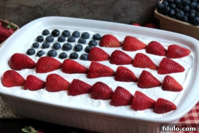 USA Flag Eclair Cake, a patriotic layered dessert with cream and berries.