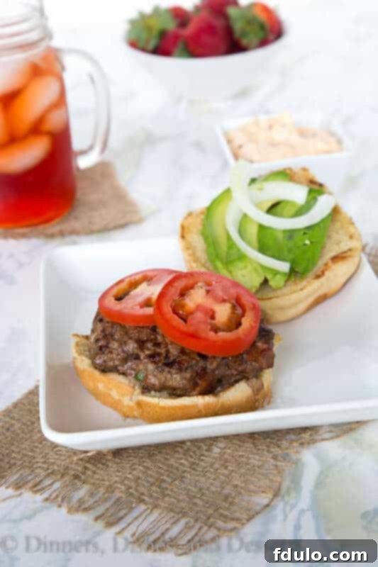 Juicy Jalapeno Bacon Burger with melted cheese and fresh toppings, ready for grilling season.